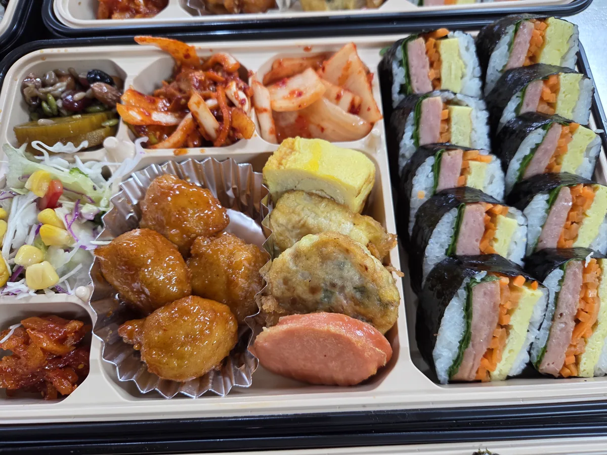 김밥과 완자, 달걀말이, 전, 샐러드와 김치를 담은 도시락